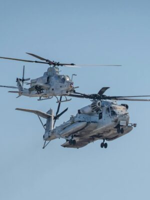 Two military helicopters perform during an airshow showcasing aviation prowess.